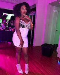 a woman in a white dress posing at a party
